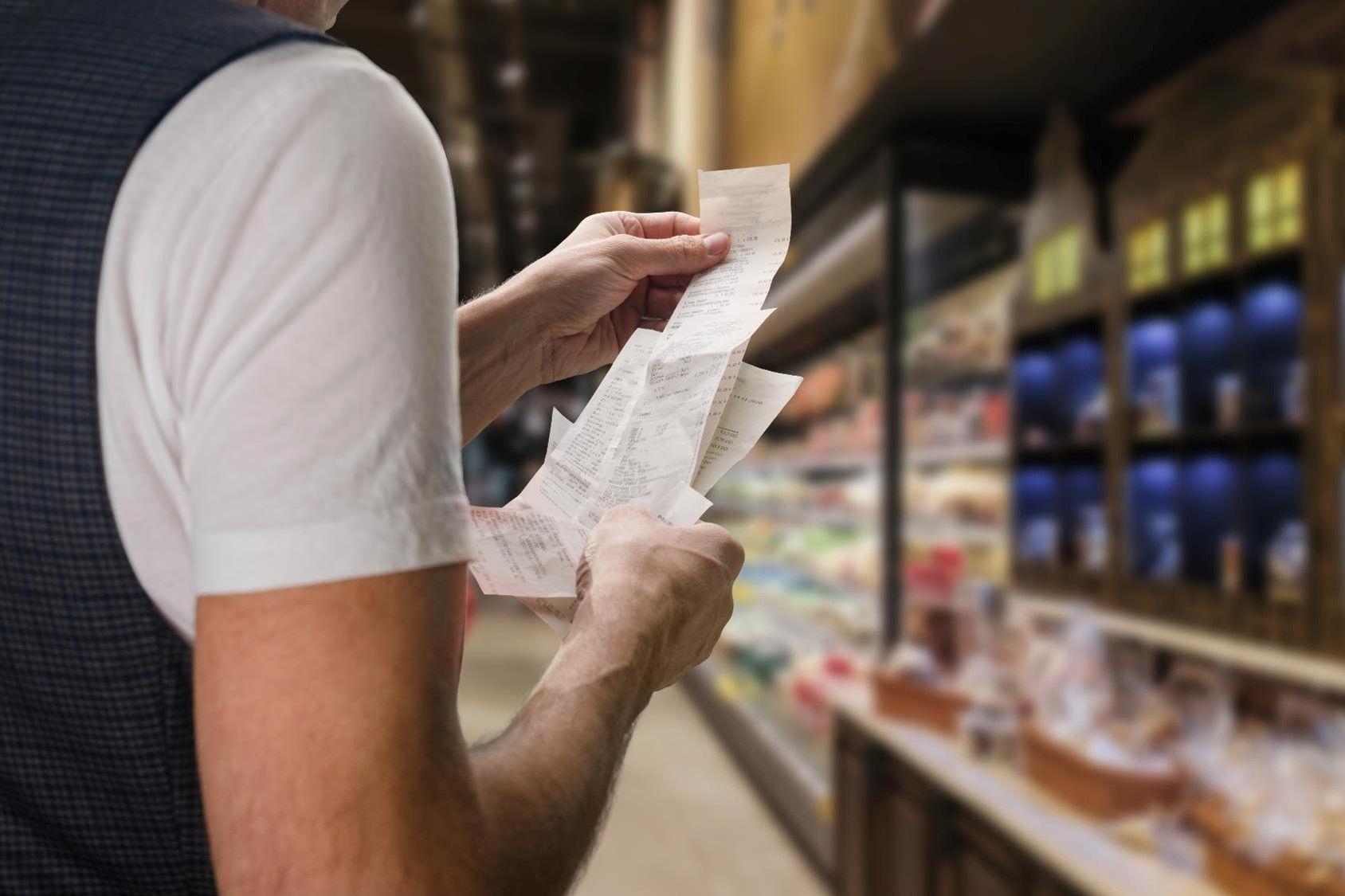 Bilde av person som ser på kvitteringer når hen er i butikken.